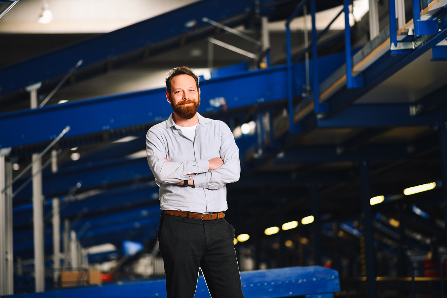 stojící ředitel s pozadím třídící linky 